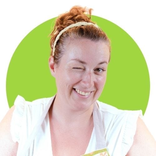 A smiling woman with curly hair wearing a white top and headband winks at the camera, posing in front of a bright green circle background.