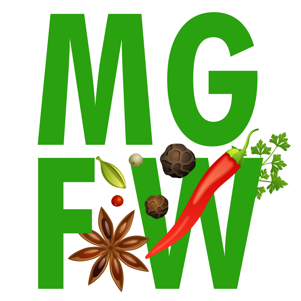 Large green letters "MGFW" with various spices interspersed, including star anise, cardamom, black pepper, white pepper, a red chili, and coriander leaves. The spices are arranged creatively around and on the letters.