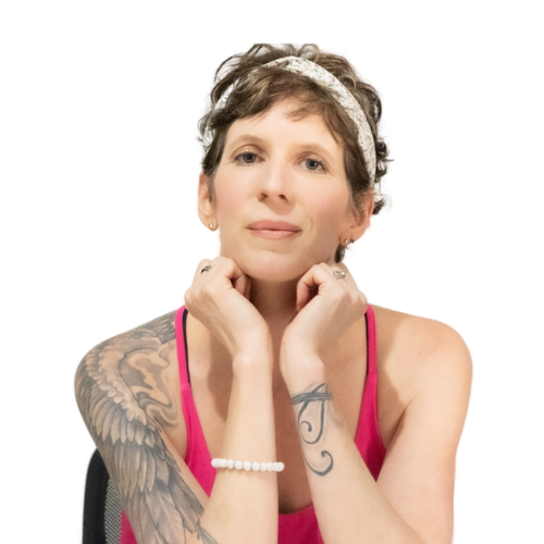 Person with short hair and a floral headband, resting their chin on clasped hands. They have tattoos on their left arm and wear a pink tank top and a white beaded bracelet, seated against a white background.